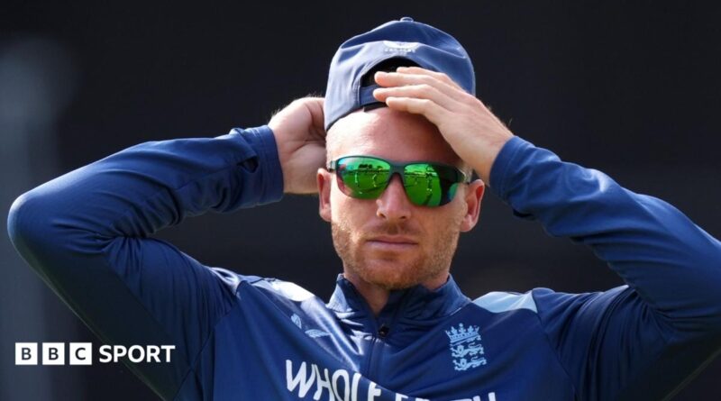 Jos Buttler rubs his head, while wearing sunglasses and a cap