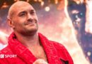 Tyson Fury holds up his hand and is wearing a boxing glove and Anthony Joshua holds up two fingers and has a Union Jack over his shoulders