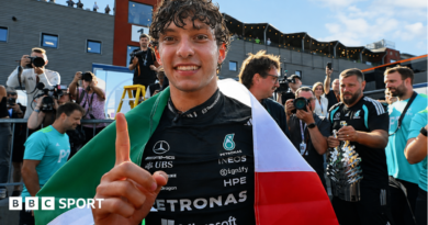 Kimi Antonelli celebrates after winning the Belgium Grand Prix, with an Italian flag draped over his shoulders