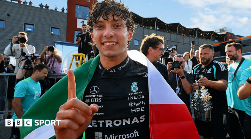 Kimi Antonelli celebrates after winning the Belgium Grand Prix, with an Italian flag draped over his shoulders