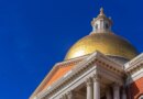 The gold dome of the Massachusetts State House stands against a blue sky.