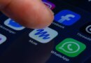A close-up of a human finger pressing the Muse app icon inside a folder containing Meta apps on a smartphone screen.