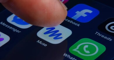 A close-up of a human finger pressing the Muse app icon inside a folder containing Meta apps on a smartphone screen.