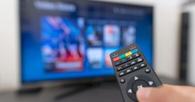 A remote being held in front of a Smart TV.