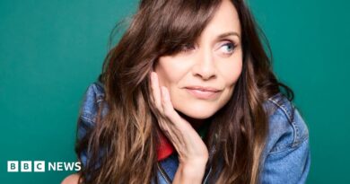 Promotional photograph of Natalie Imbruglia in a denim jacket, with her head resting in her right hand