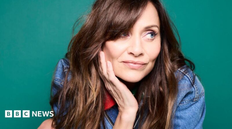 Promotional photograph of Natalie Imbruglia in a denim jacket, with her head resting in her right hand