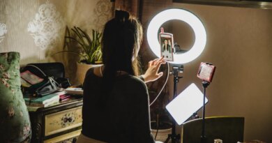 female influencer filming content using phone in a bedroom
