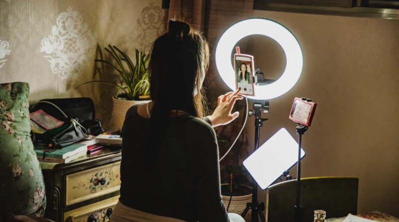female influencer filming content using phone in a bedroom