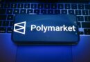 In this photo illustration, a Polymarket logo is displayed on a smartphone on top of a laptop.