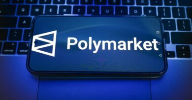 In this photo illustration, a Polymarket logo is displayed on a smartphone on top of a laptop.