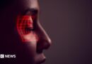 Facial Recognition Technology Concept As Woman Has Red Grid Projected Onto Eye In Studio