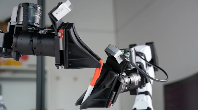 XDOF's robotic arms manipulate a pen and cap.