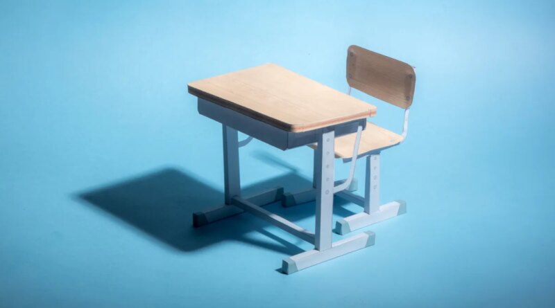 Empty school desk on a blue background.