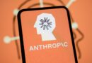 The Anthropic logo is displayed on the screen of a smartphone with the company's branding in the background.