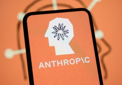 The Anthropic logo is displayed on the screen of a smartphone with the company's branding in the background.