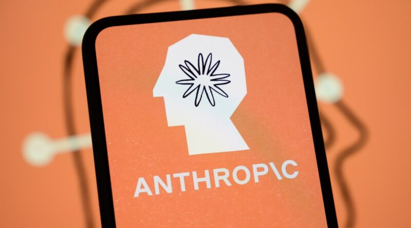 The Anthropic logo is displayed on the screen of a smartphone with the company's branding in the background.
