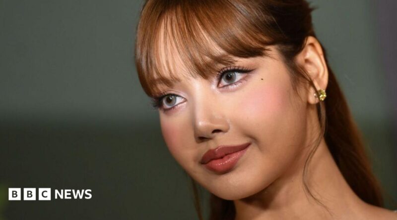 Lisa Manobal is pictured on a red carpet, looking off camera. A camera flash illuminates her eyes