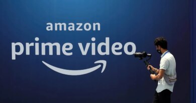 A cameraman records a video near the poster of Amazon Prime Video launch in Mumbai.