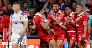 George Williams looks dejected as Tonga celebrate