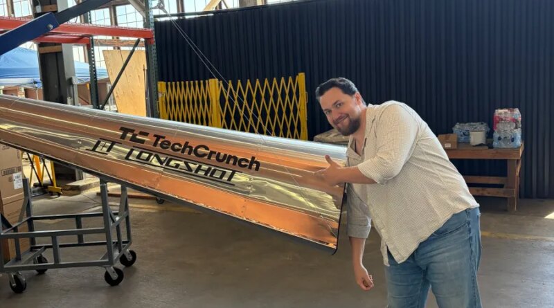 Longshot CEO and cofounder Mike Grace with a projectile designed to be fired from his company's enormous gun.