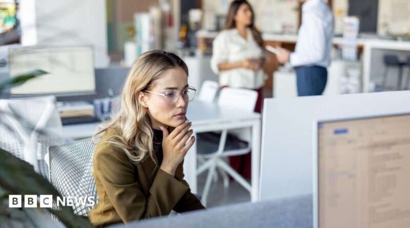 A woman with brown hair talks to someone off-camera.
