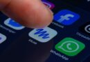 A close-up of a human finger pressing the Muse app icon inside a folder containing Meta apps on a smartphone screen.