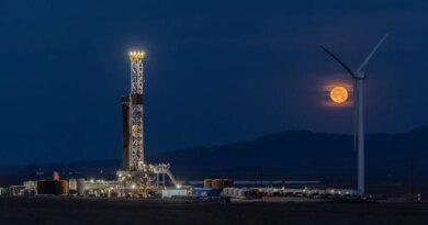Fervo's drilling rig lit up at night with the moon rising in the background.